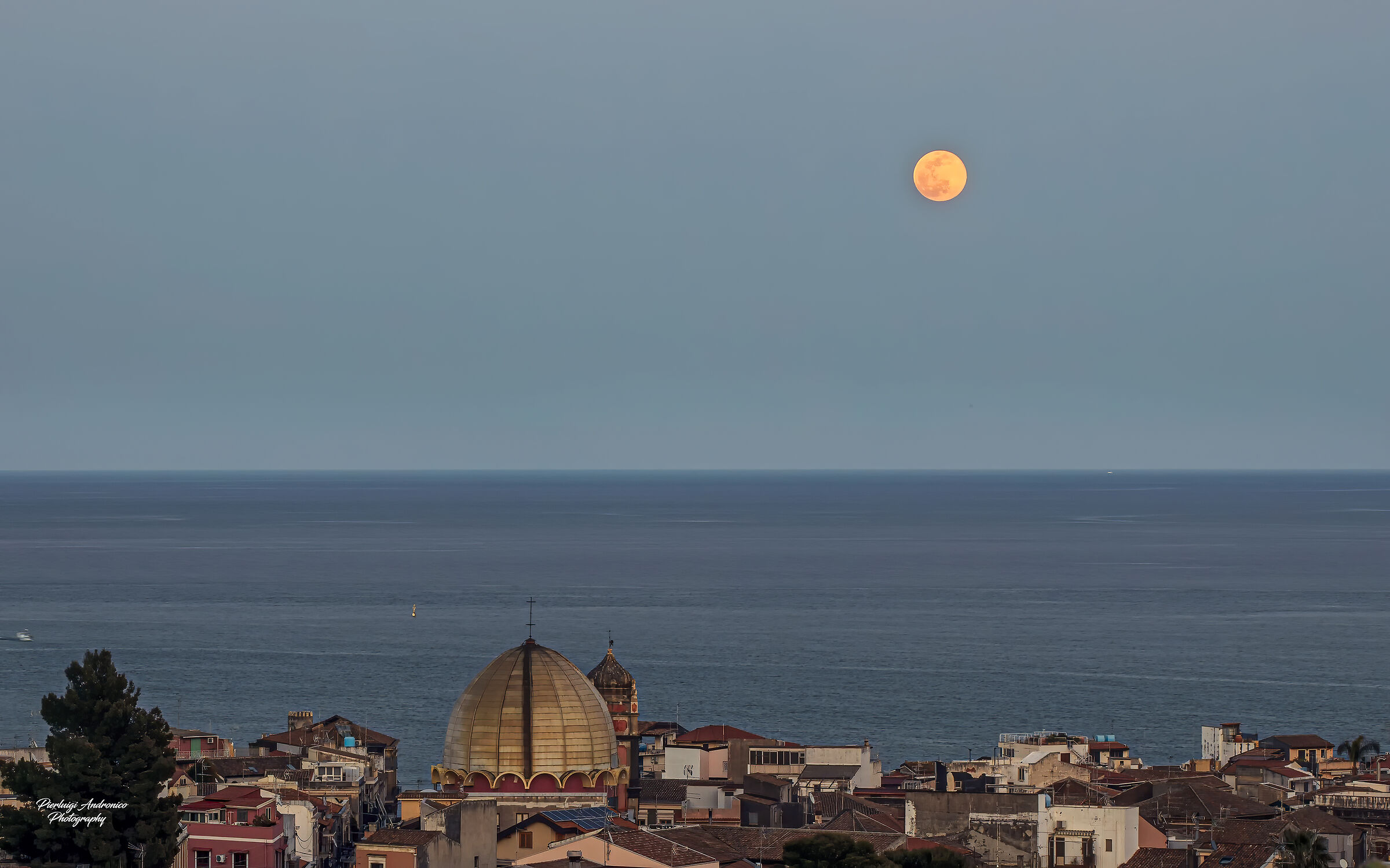Lunar sunrise observed in the sky of Aci Castello...