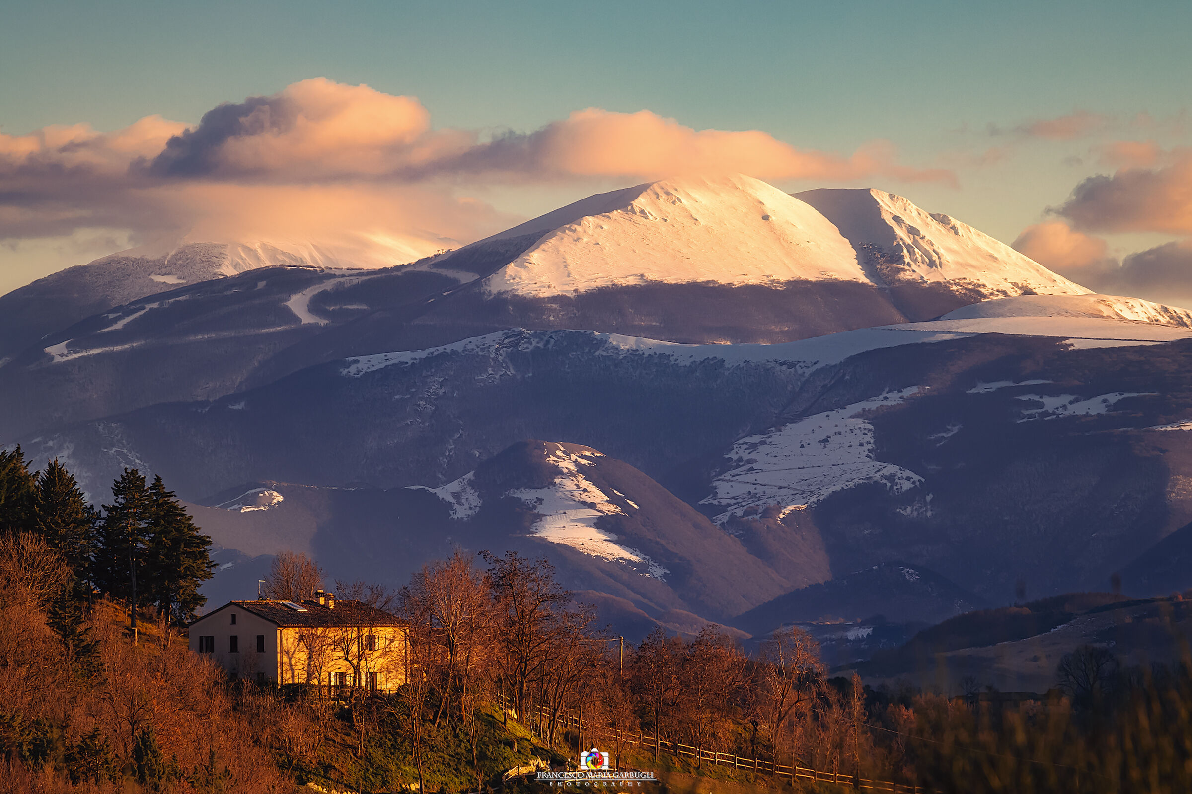 Farmhouse at sunset and snow-capped peaks...